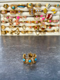 Bague dorée motifs solaires et détails turquoise