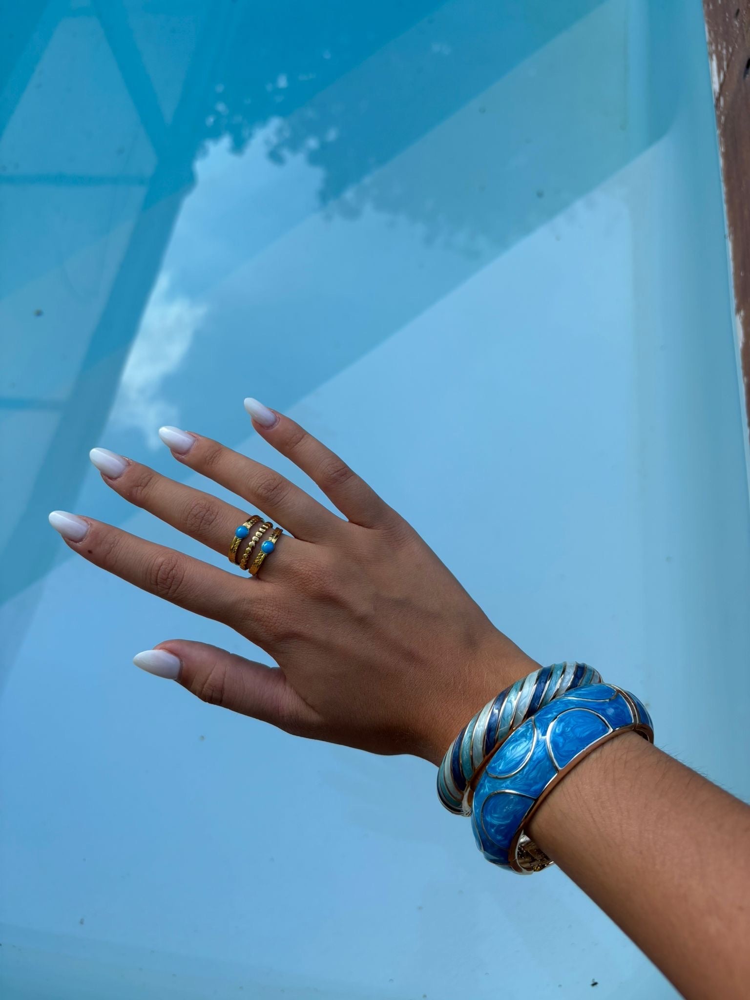 Bague dorée ajustable multirangs avec détails turquoise portée
