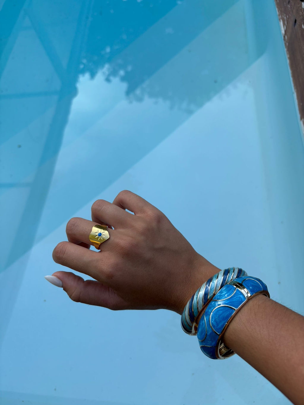 Bague chevalière dorée avec détail bleu portée