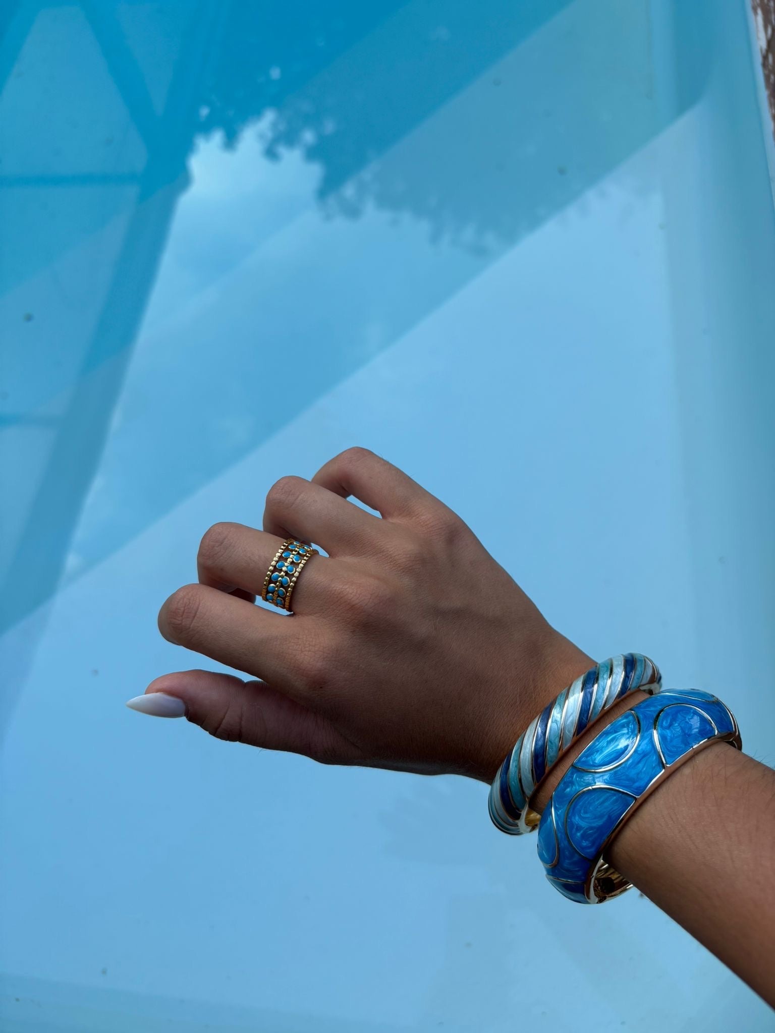 Bague dorée multirangs ornée de détails turquoise portée