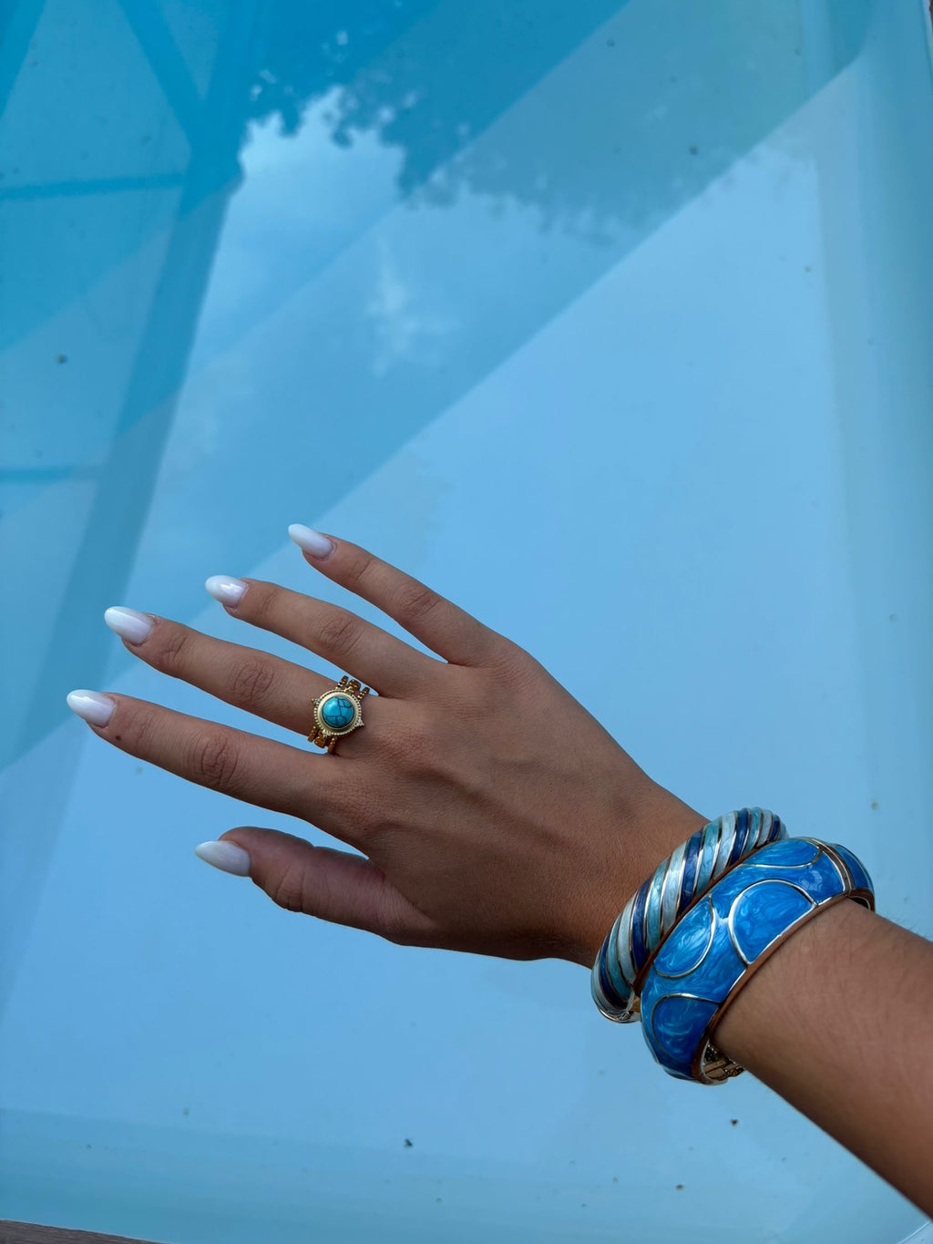 Bague dorée à cabochon turquoise rond portée