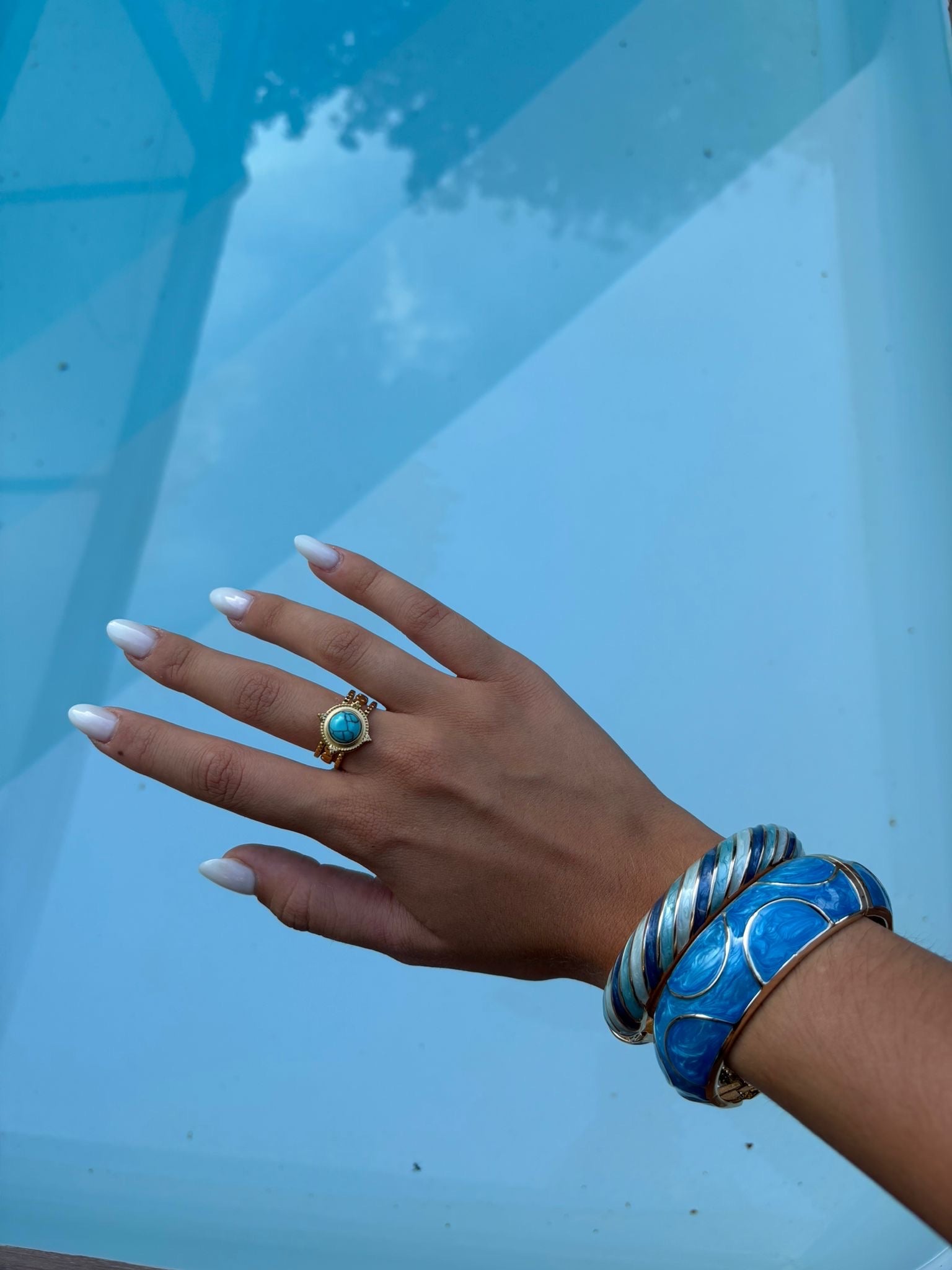 Bague dorée à cabochon turquoise rond portée
