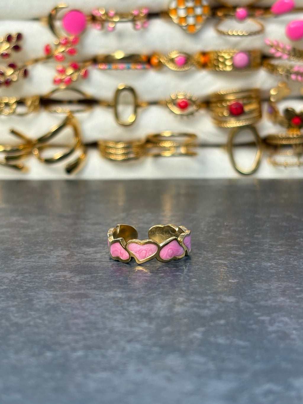 Bague dorée ajustable composée de cœurs roses